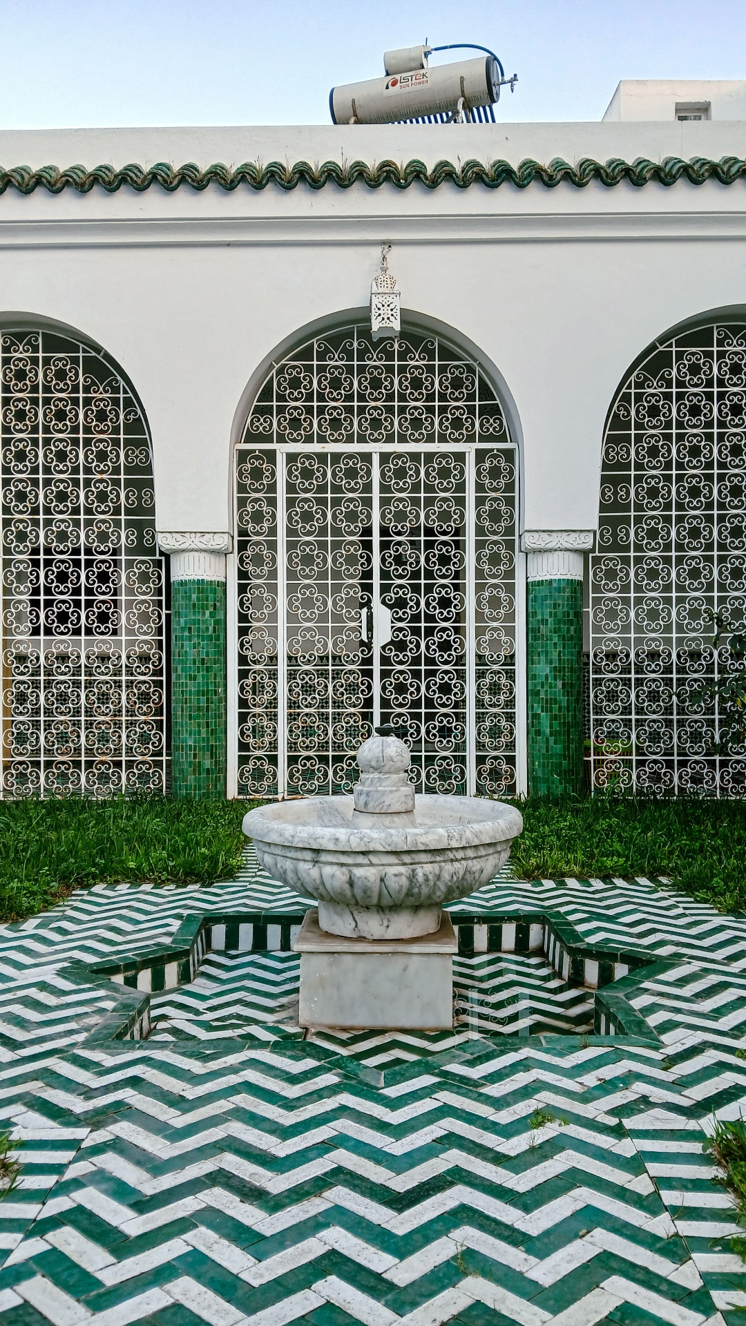 Fuente con zellige verde y suelo en zigzag