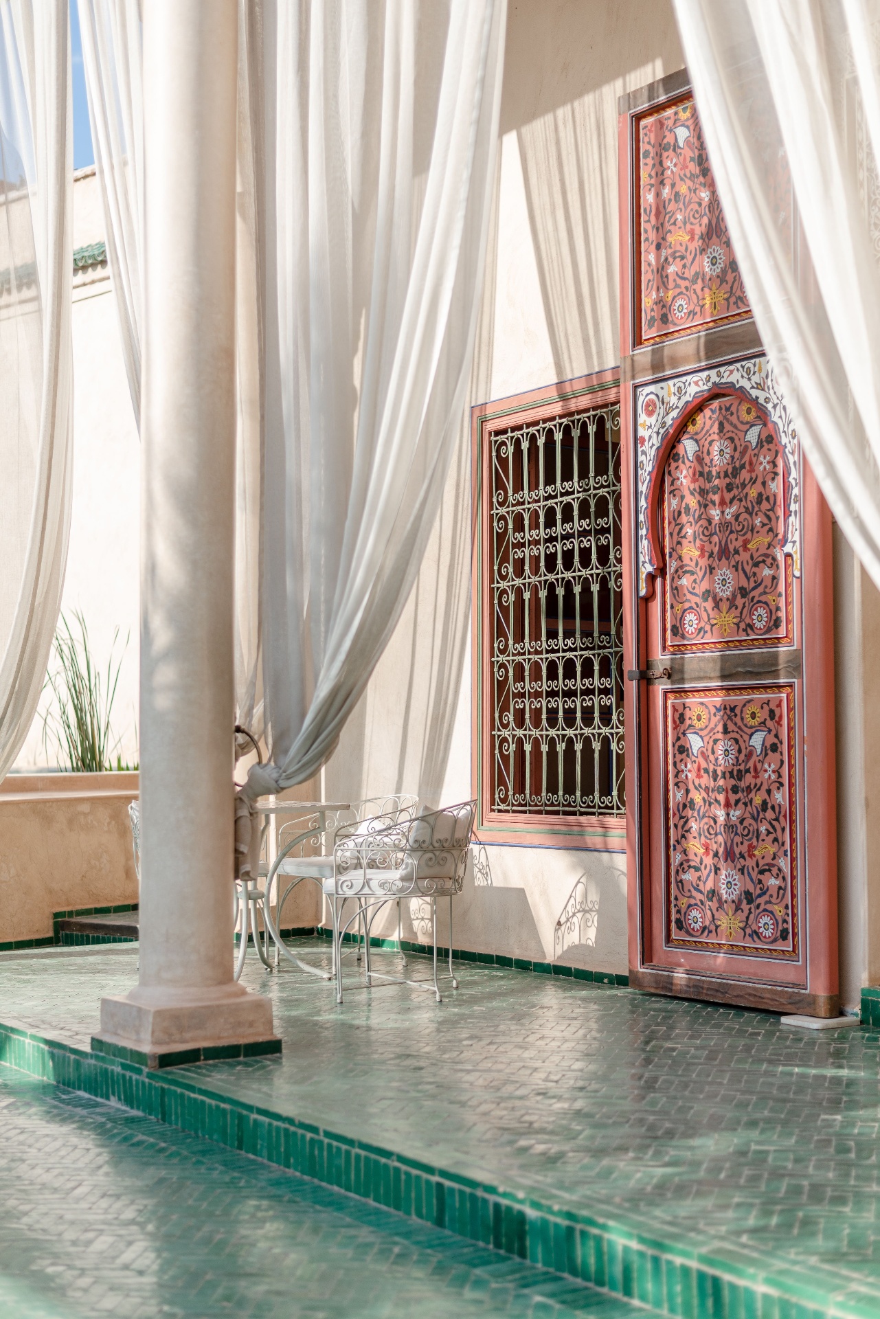 Terraza de riad con zellige verde y puerta pintada